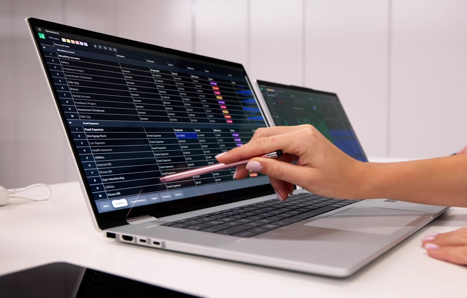 Pessoa manipulando uma planilha digital em um laptop com software de gerenciamento de tarefas, ideal para produtividade e organização.