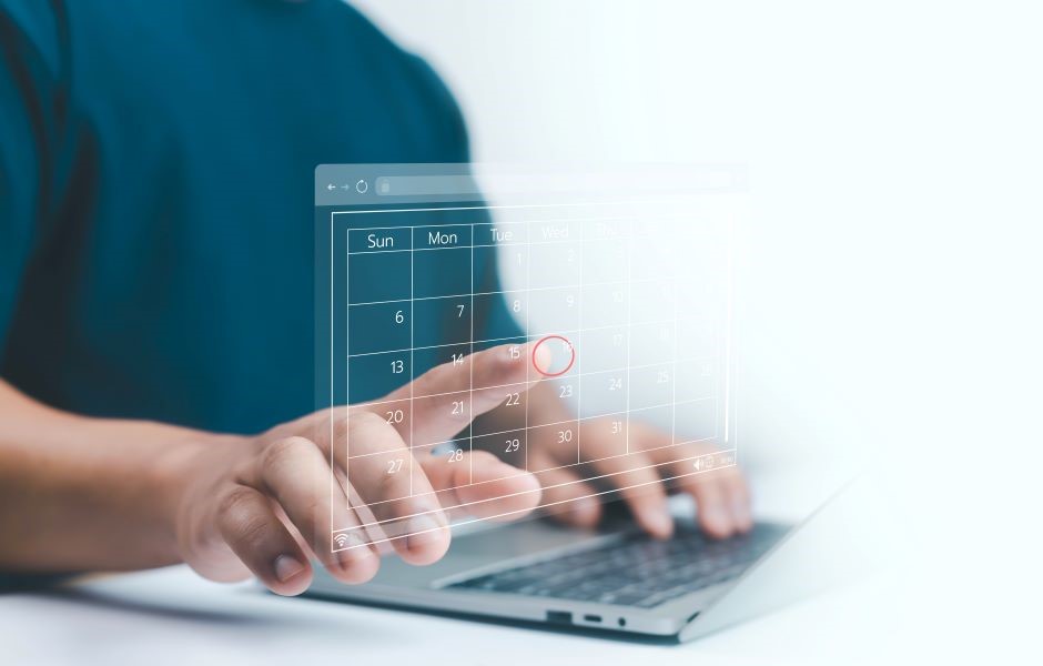 Pessoa usando um laptop com interface holográfica de calendário, representando organização e planejamento digital. Tecnologia moderna e produtividade.
