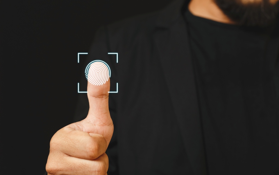 Close-up de uma pessoa realizando autenticação por impressão digital, simbolizando controle de acesso, registro de ponto eletrônico e segurança de dados.